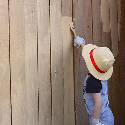 a small child painting a new fence